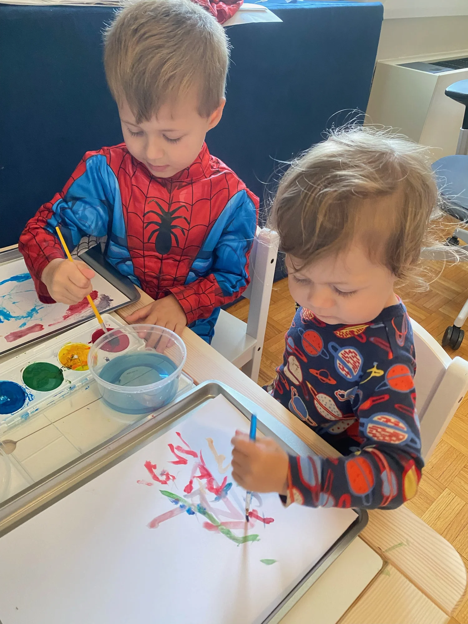 Two children painting together